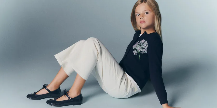 Girl in a navy Bonpoint x MoMA cardigan with a flower motif