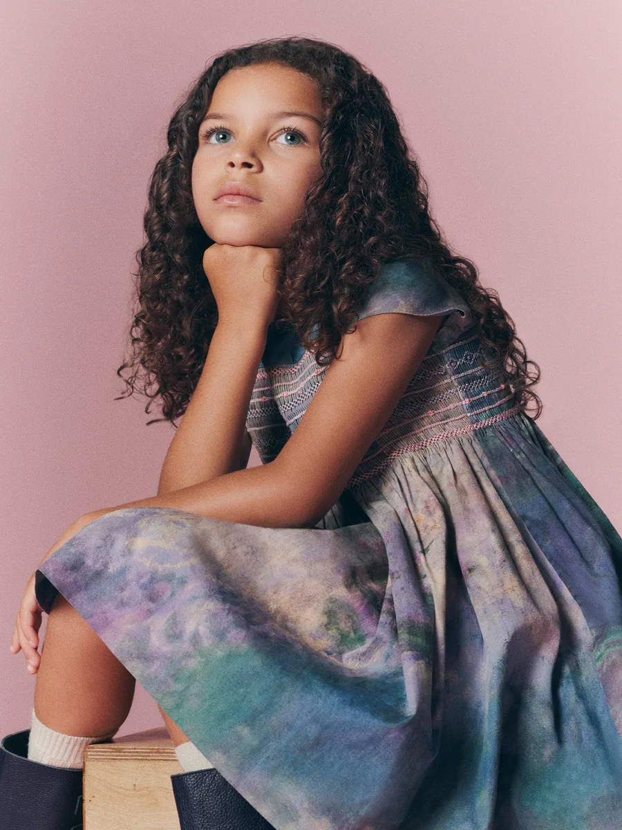 Girl in the smocked Bonpoint x MoMA dress with the water lily print
