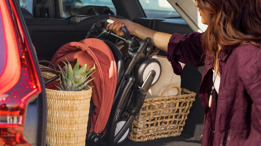 Folded Stokke YOYO⁵ pushchair being lifted into a car boot